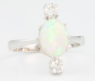 An 18ct white gold oval opal and diamond ring, the centre stone approx. 1.35ct flanked by 2 brilliant cut diamonds approx 0.3ct, size O 