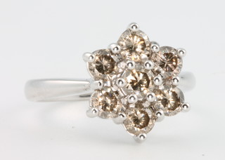 An 18ct white gold 7 stone diamond daisy style ring, size M