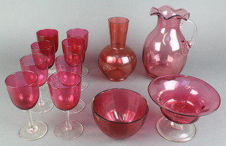 A matched set of 8 Victorian cranberry wines, ditto jug, 2 bowls and a vase 