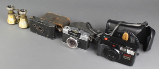 A Kodak vest pocket camera with instructions, an Olympus-10 camera, a Pentax 70-X camera and a pair of opera glasses, 