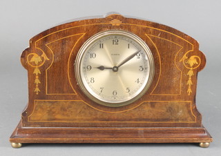 An Art Deco 8 day timepiece with silvered dial and Arabic numerals contained in a shaped inlaid mahogany case 