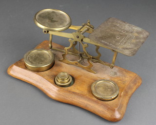 A pair of brass letter scales with 5 weights 