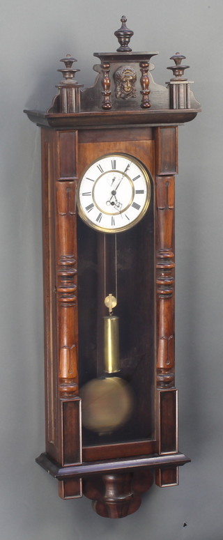 A Vienna style regulator, the 6 1/2" porcelain dial with Roman numerals and subsidiary second hand,  contained in a carved walnut case  