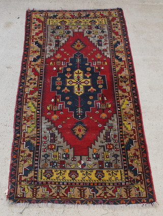 A yellow and blue ground Persian rug with central stylised medallion 100" x 48" 