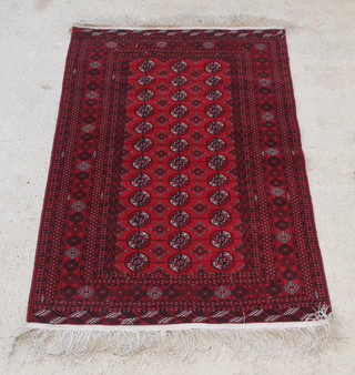 A red ground Bokhara rug with 36 octagons to the centre within multi-row borders 72" x 51" 