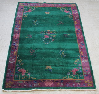 A 1930's green and purple ground floral patterned Chinese rug 101" x 73"
