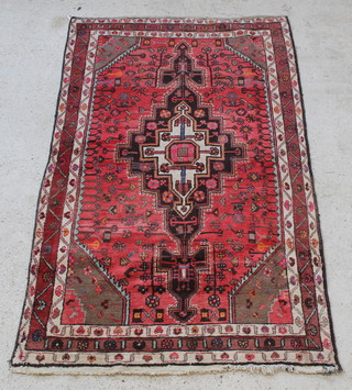 A red and white ground Persian Behbahan rug with central medallion 89" x 53"