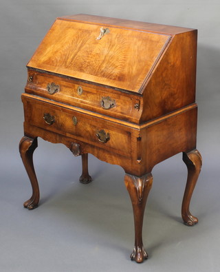 Hamptons of Bond Street, a Queen Anne style figured walnut and crossbanded bureau, the fall front revealing a fitted interior above 2 long drawers, raised on carved cabriole supports 37 1/2"h x 28 1/2w x 16 1/2"d 