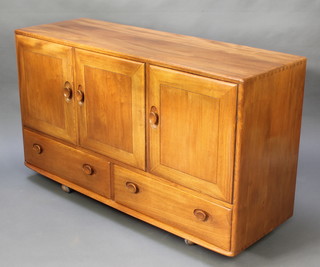 A Windsor Ercol light elm sideboard fitted 3 cupboards enclosed by panelled doors above 2 long drawers with carved oval handles, 30"h x 51"w x 17"d 