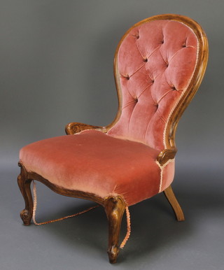 A Victorian oak show frame nursing chair upholstered in pink buttoned material 