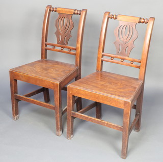 A pair of Georgian mahogany splat back hall chairs with pierced vase shaped backs and solid seats, raised on square tapering supports 