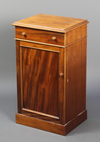 A Victorian mahogany bedside cabinet fitted a drawer above a cupboard enclosed by a panelled door with tore handles, raised on a platform base 29"h x 16 1/2"w x 12 1/2"d 