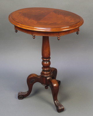 A Victorian oval mahogany snap top wine table with quarter veneered top on a turned column and tripod base 28"h x 22" x 18"d 
