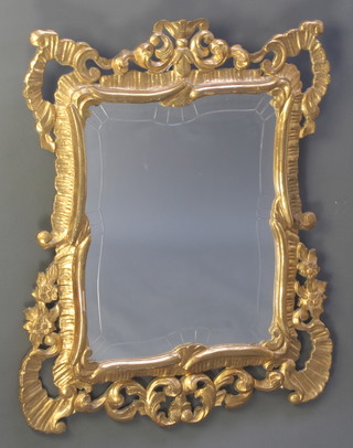 A shaped cut glass plate mirror contained in a decorative gilt wood frame 34"h x 25"w 