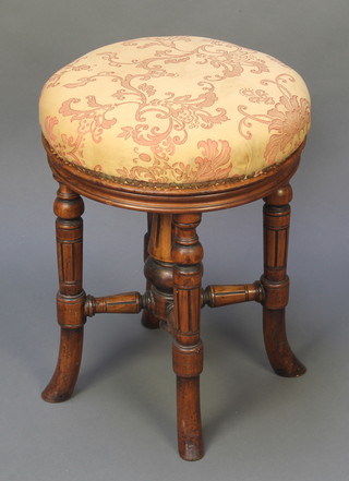 A Victorian circular carved walnut revolving piano stool with turned column to the centre, raised on 4 fluted outswept supports 19"h x 15" diam. Base marked 6969 518 