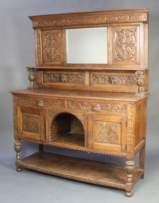 A Victorian carved oak sideboard with moulded cornice, the raised back fitted a shelf and a mirror above 2 drawers and a recess flanked by a pair of cupboards with undertier having cup and cover supports, raised on bun feet, heavily carved throughout 74"h x 60"w x 21 1/2"d 