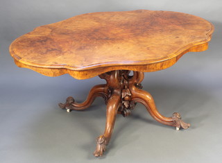 A Victorian shaped figured walnut loo table raised on a heavily carved pillar and tripod base 28" x 57" x 45" 
