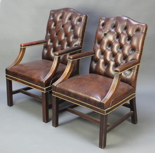 A pair of Gainsborough style mahogany open arm library chairs upholstered in brown buttoned leather, raised on square tapering supports with box stretcher 