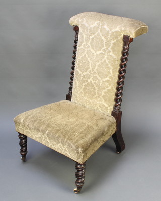 A Victorian mahogany prie-dieu chair with spiral turned columns to the sides, raised on spiral turned supports, upholstered in green material 