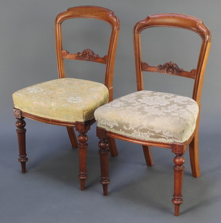 A pair of Victorian carved mahogany bar back chairs with carved mid rails and upholstered seats, raised on turned supports 