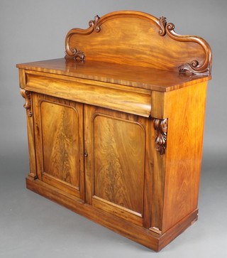 A Victorian mahogany chiffonier with raised shaped back, the base fitted a drawer above a cupboard enclosed by arched panelled doors, raised on a platform base 51"h x 48"w x 19"d 