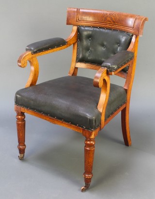 A Victorian oak open arm carver/desk chair with upholstered seat and back, raised on turned supports
