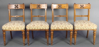 A set of 4 Victorian aesthetic movement carved oak bar back dining chairs with pierced bar backs and upholstered seats, raised on turned supports
