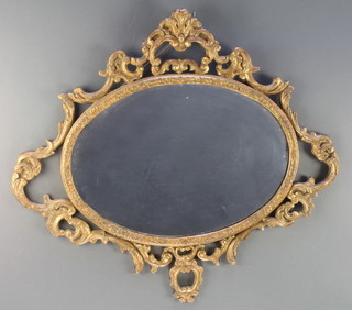 An oval plate wall mirror contained in a carved wood and plaster frame 26 1/2" x 29 1/2" 