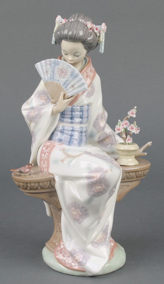 A Lladro figure of a seated Japanese lady on a bench beside a bird 9", boxed