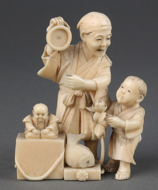 A Japanese Meiji period carved ivory okimono of a street seller with boy beside him and a fish at his feet 3" 