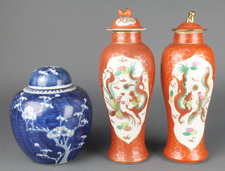 A matched pair of Japanese ochre ground oviform vases decorated with panels of dragons and birds with shi shi finials 12 1/2" together with a blue and white prunus ginger jar and lid 8" 