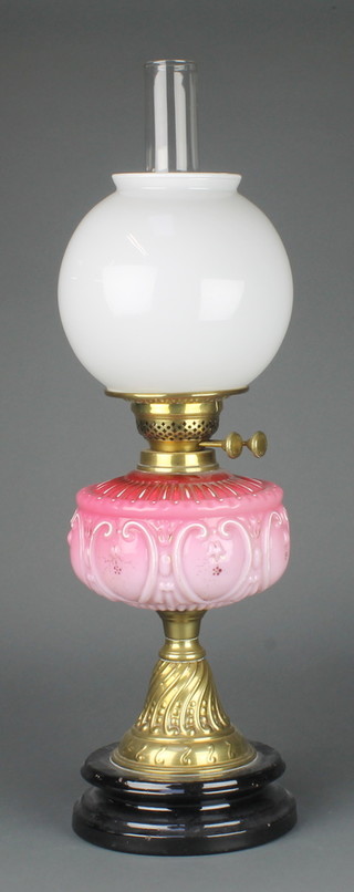 A Victorian opaque pink glass oil lamp reservoir raised on embossed gilt metal base, with opaque glass shade and clear glass chimney 