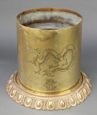 A Continental First World War brass shell case, the base marked RKMH 38, engraved with dragons, raised on an associated base 9" x 8 1/2" 