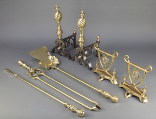 A pair of Art Nouveau polished brass fire dogs with floral decoration, a pair of 19th Century style polished steel and brass fire dogs together with a Victorian style 3 piece fireside companion set comprising poker, shovel and tongs 
