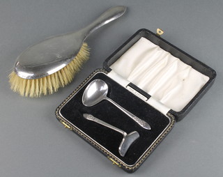 A silver backed hair brush and a cased plated pusher and spoon