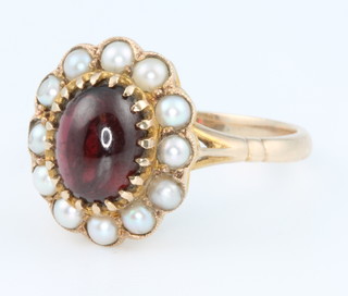 A 9ct yellow gold cabuchon cut garnet and seed pearl ring size O 