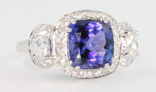 An 18ct white gold tanzanite and diamond ring, the centre stone approx 2.8ct flanked by baguette cut diamonds approx. 0.21ct and brilliant cut diamonds approx 0.39ct, size N