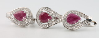 A silver paste and ruby ring size N with matching ear clips 