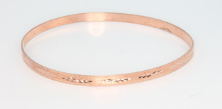 A 9ct rose gold bangle with bright cut decoration 5.7 grams