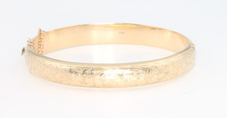 A 9ct yellow gold bangle with chased decoration 12.2 grams