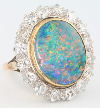 An 18ct yellow gold and platinum black opal and diamond ring, the oval centre stone approx. 5.9ct surrounded by 16 brilliant cut diamonds, size O 1/2