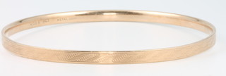A 9ct yellow gold engine turned hollow bangle, 14.9 grams gross (metal core)