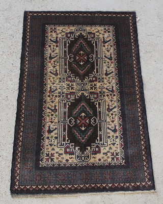 A brown and cream ground Belouch rug with 2 rectangular shaped medallions to the centre within multi-row borders 53" x 31" 