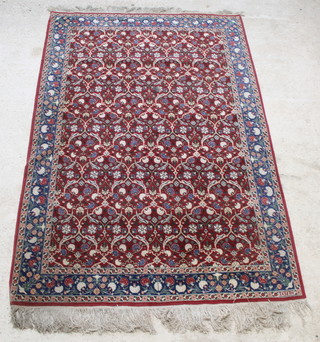A red and blue floral ground Hereke rug with all-over floral design, signed to the bottom right hand corner Hereke, 106" x 68" 