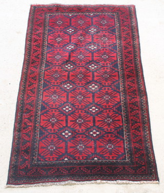 A red and blue Afghan rug with 21 stylised octagons to the centre, in wear, 78" x 45" 