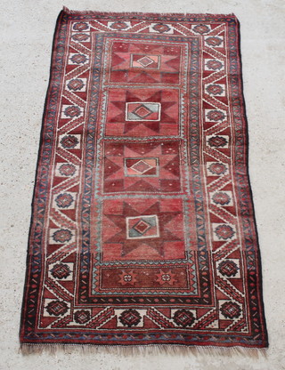 A red ground Caucasian rug with 4 square shaped medallions and stylised stars to the centre,  76" x 39"
