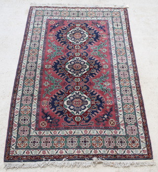 A red, green and blue ground Caucasian rug with 3 octagons to the centre 92" x 56" 