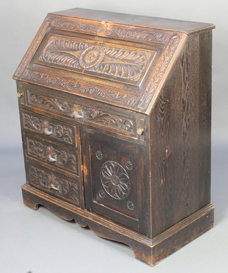 A Victorian carved dark oak bureau, the fall front revealing a well fitted interior above 1 long drawer and 3 short drawers, flanked by a cupboard, raised on bracket feet 39"h x 36"w x 18"d 