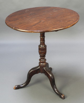 A 19th Century circular oak snap top tea table, raised on a turned column and tripod base 29"h x 26 1/2" diam. 