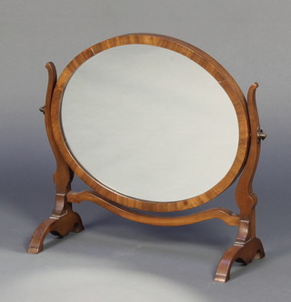An oval plate table mirror contained in a mahogany swing frame 16"h x 18"w x 7"d 